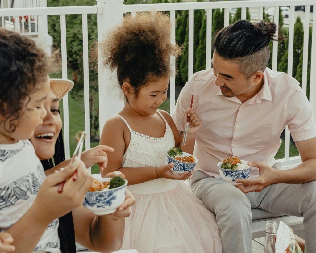 girl and family eating rice bowls